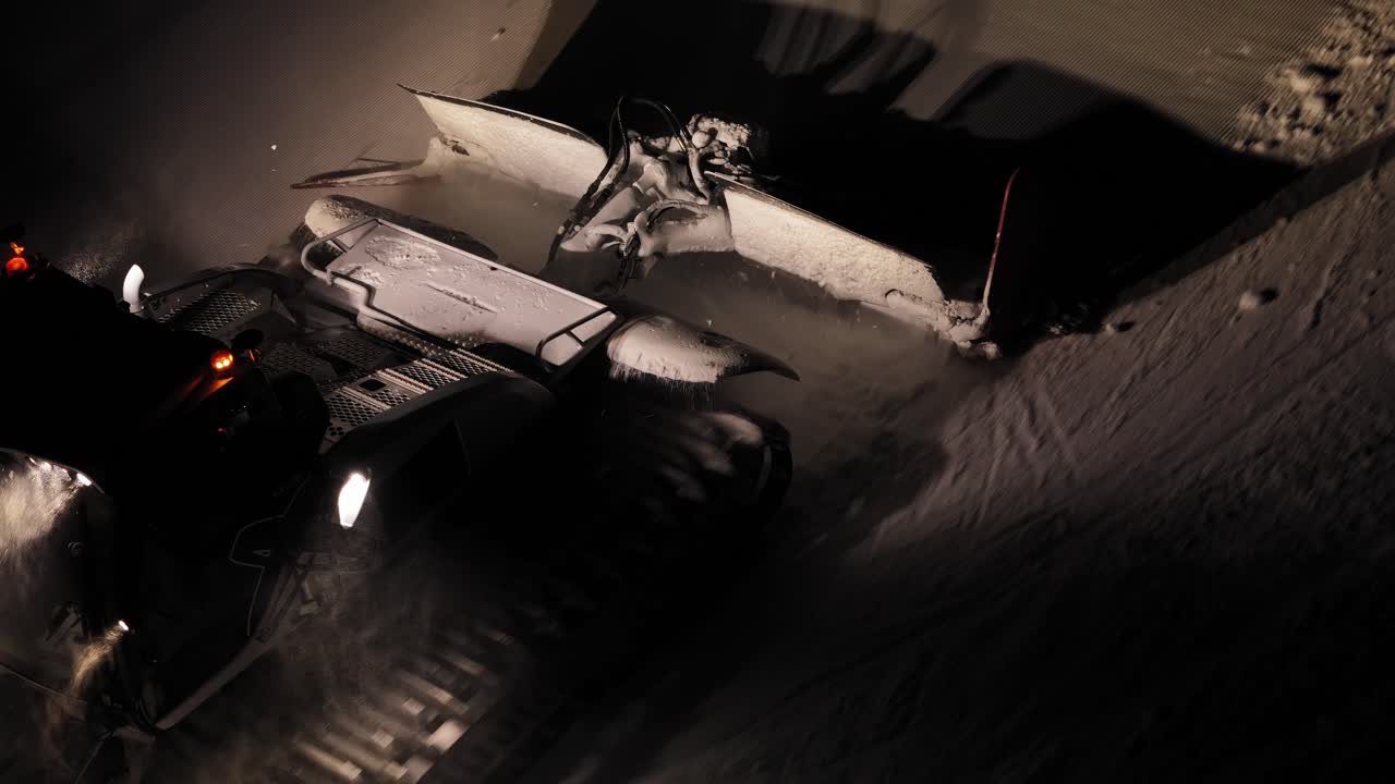 PistenBully grooming snowy slopes at night in the Dolomites, Italy, with illuminated headlights