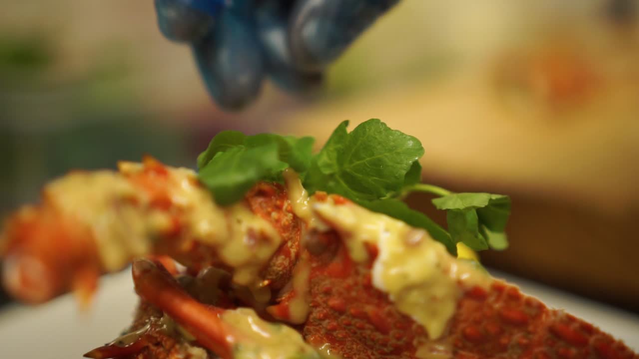 slowmo - 클로즈업 - 조리된 뉴질랜드 가재에 허브를 얹는 것