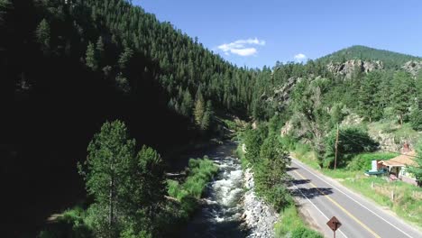 Drone-rising-shot-above-Highway-34-near-Estes-Park-Colorado-revealing-mountains-and-forests