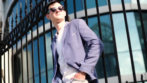 portrait of confident businessman wearing in sunglasses and walking at street.