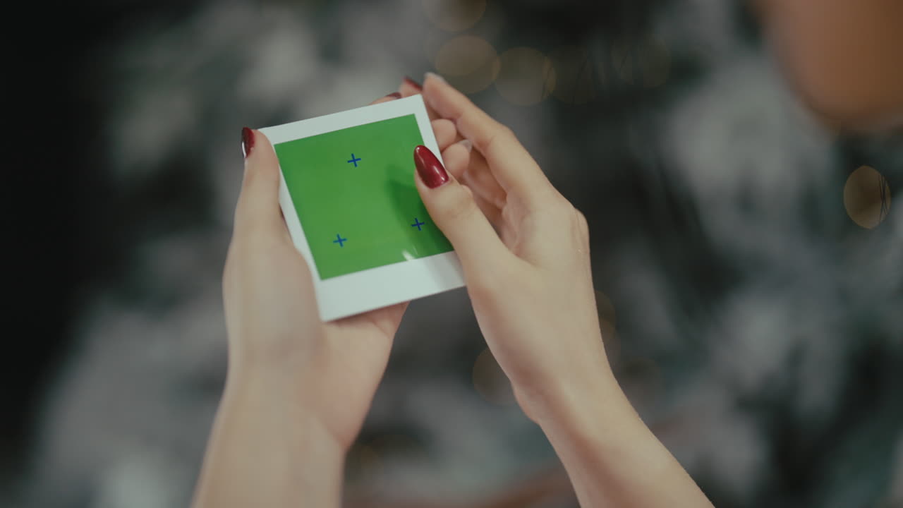 Woman holding a green screen polaroid picture