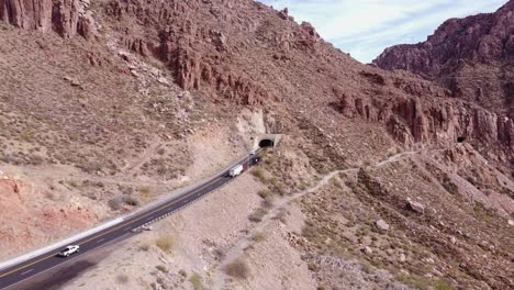 Aerial-view-of-a-semi-driving-into-Queen-creek-tunnel-on-highway-60-on-the-side-of-a-mountain-in-superior-Arizona