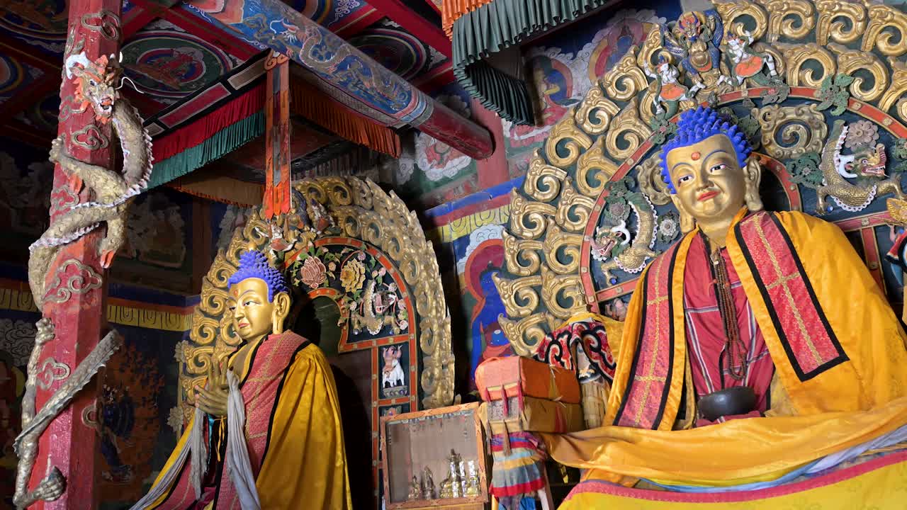 Ancient Buddhist heritage at Erdene Zuu Monastery: a row of gilded statues, ceremonial cymbals, and intricate colorful woodwork adorn the sanctuary of Mongolia's first Buddhist center