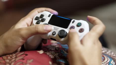 persona jugando a un videojuego con un controlador de playstation blanco.