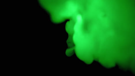 Green-puffs-of-smoke-on-black-background