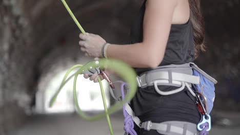 female rock climber securing rope with ascender