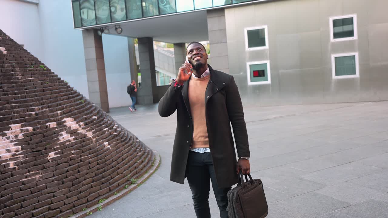 Afroamerikansk affärsman som använder mobiltelefon i stadsmiljö