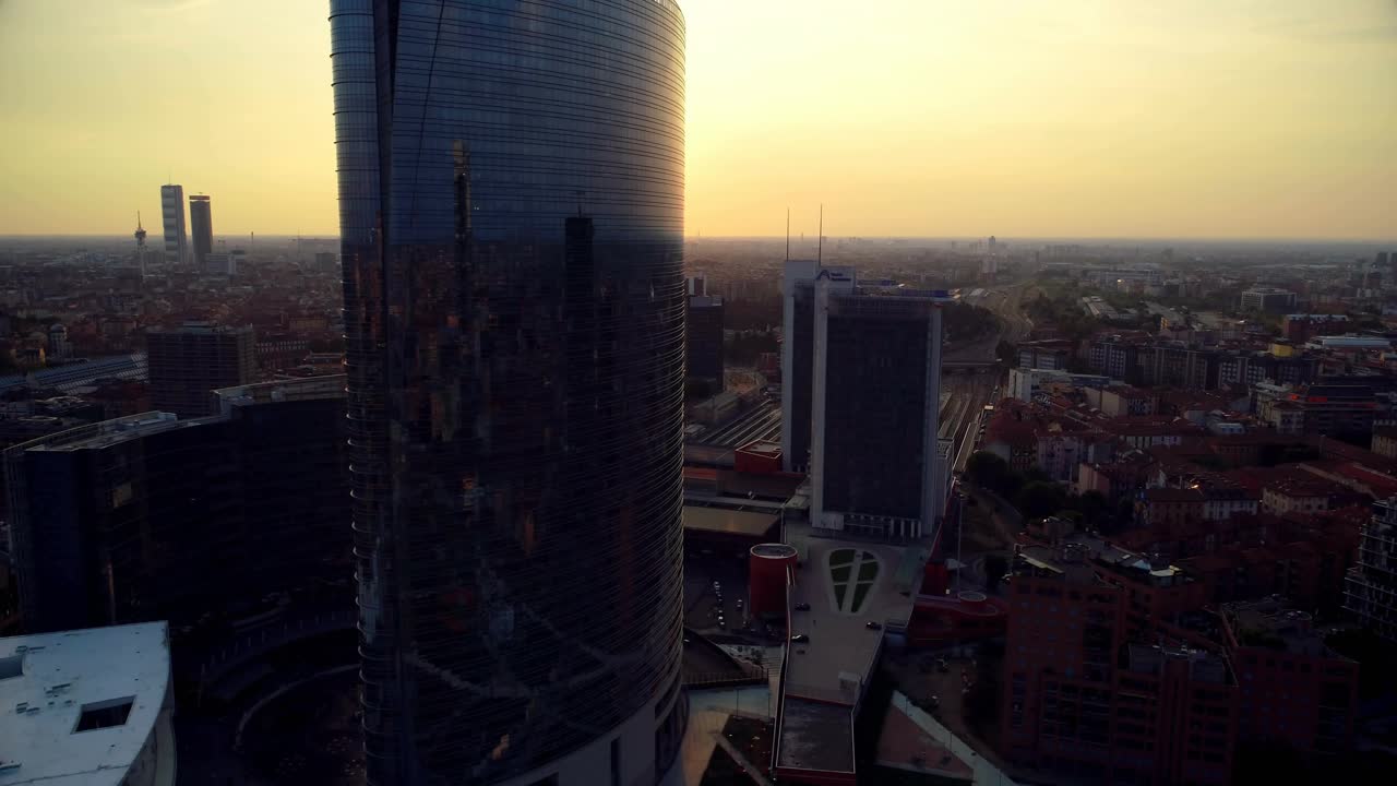 Panorâmica da câmera revelando o horizonte, selos se multiplicando ao redor da torre de vidro, mostrando o engajamento social