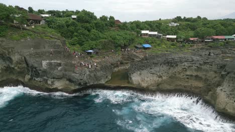 Reverse aerial shot of waves crashing at Bali Nusa Penida Angel Billabong