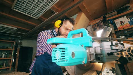 one carpenter uses saw bench while working with wood.