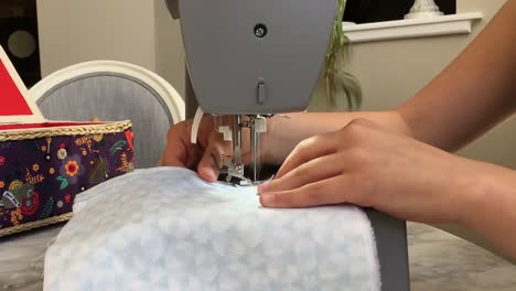 lady making homemade face masks from fabric with sewing machine, coronavirus covid-19
