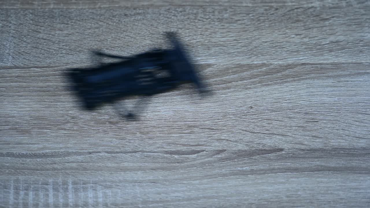 Black chasis pushed to the right on a table for a test, Tamiya Mini 4X4