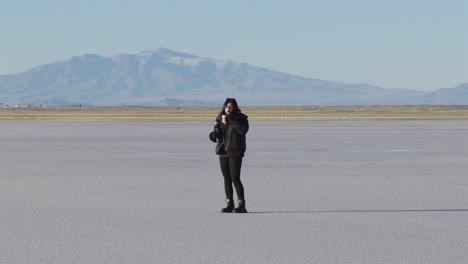 traveler holding yerba mate thermos in argentine salt desert, mindful nature moment