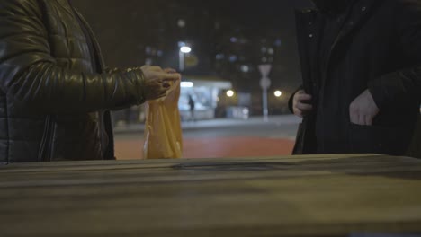 three men consume alcohol in a public area