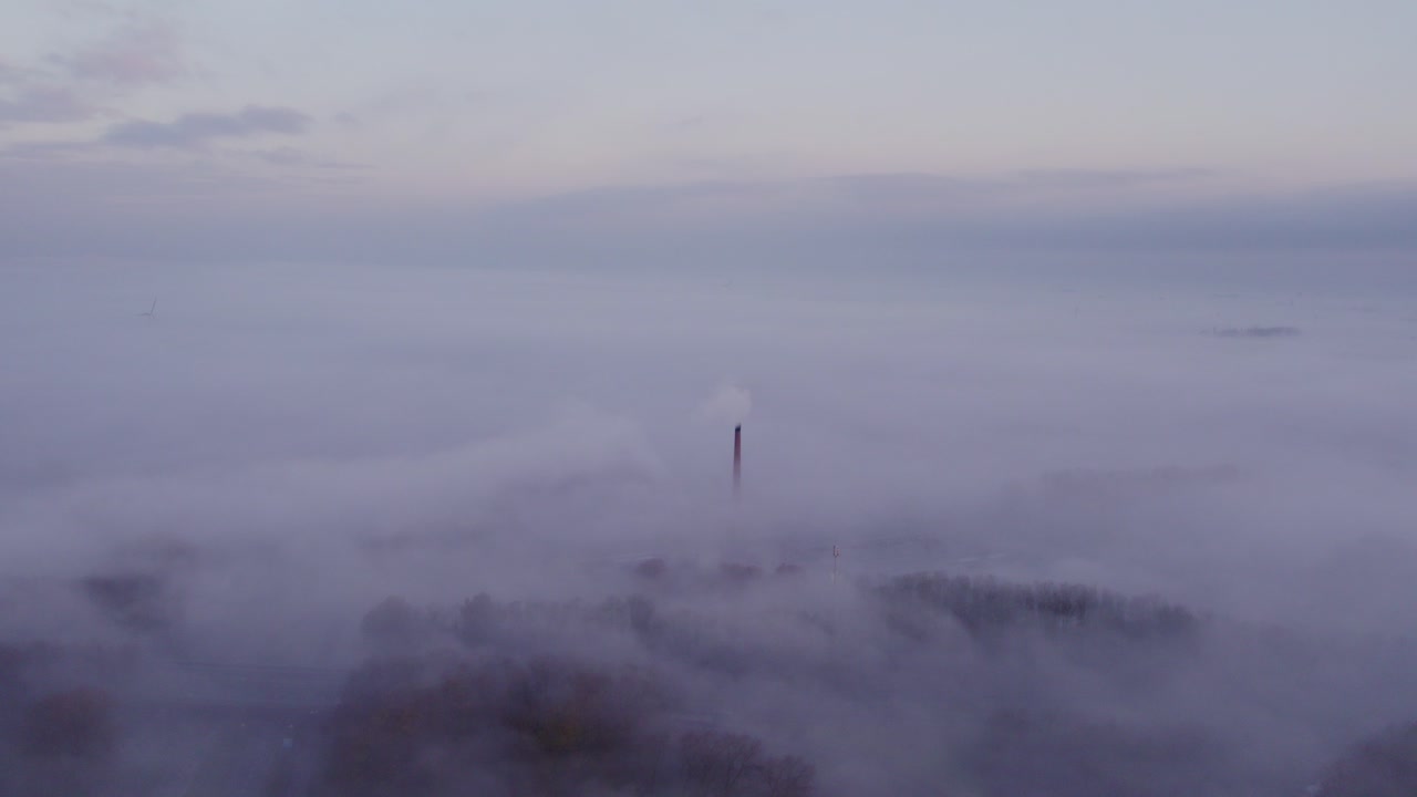 Alba nebbiosa su una chiesa storica e una fabbrica a Bolsward, che cattura una bellezza serena