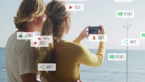 taking photo by sea, couple surrounded by social media notifications animation