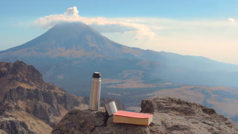 libro y café en las rocas y el volcán popocatepetl al fondo