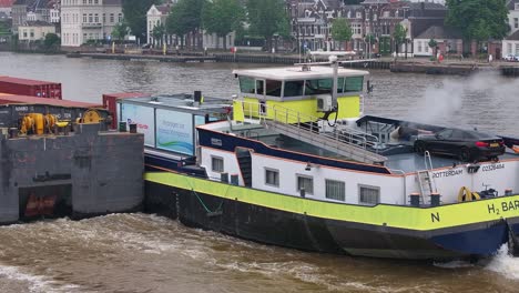 hydrogen-powered barge pushes cargo containers on a rotterdam river