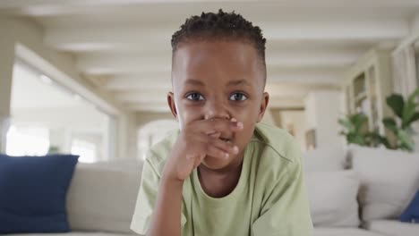 un niño afroamericano feliz haciendo una videollamada en casa, en cámara lenta