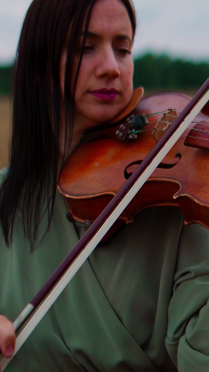 Woman Playing Violin in a Field at Sunset