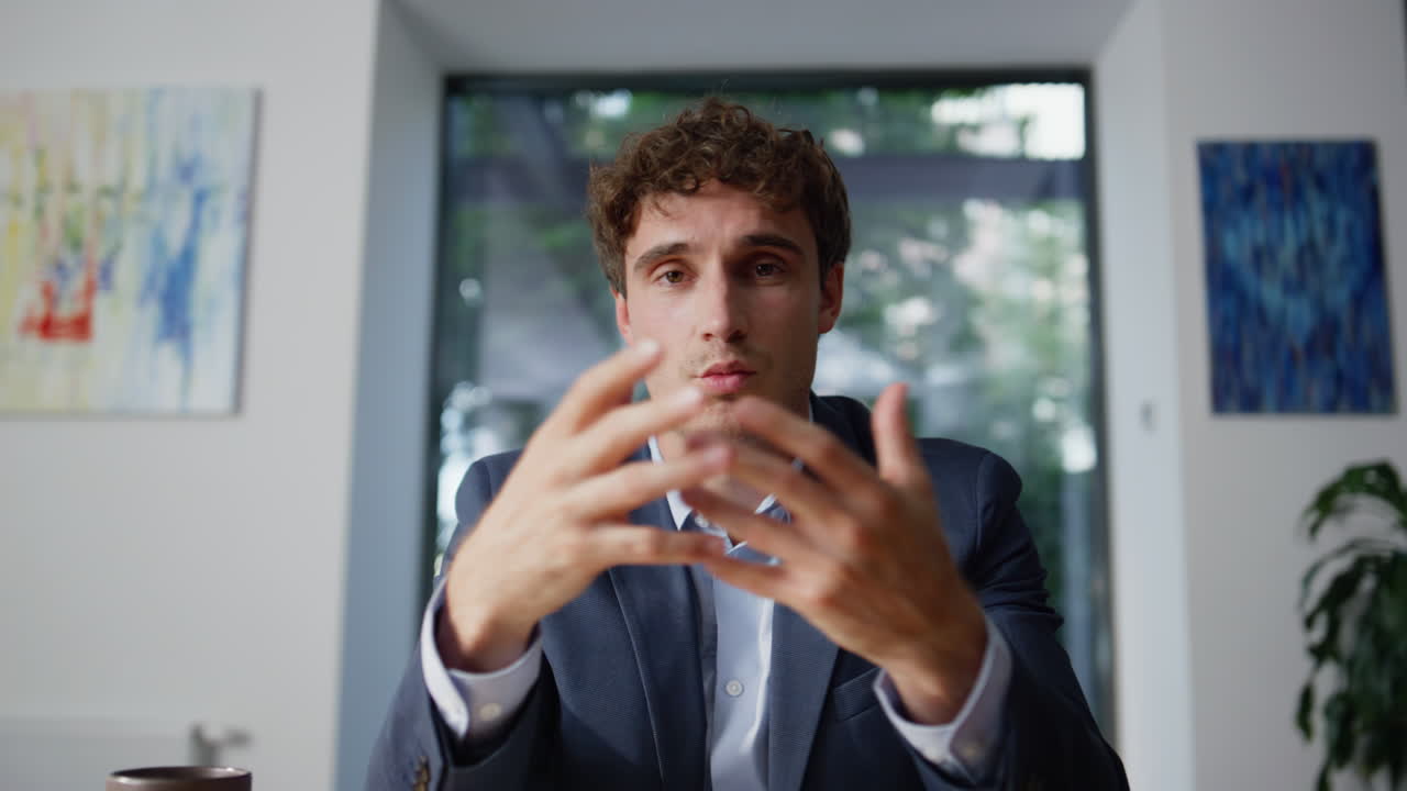 Primo piano POV di una videochiamata di un tutor online in un ufficio. Uomo sorridente che offre consulenza