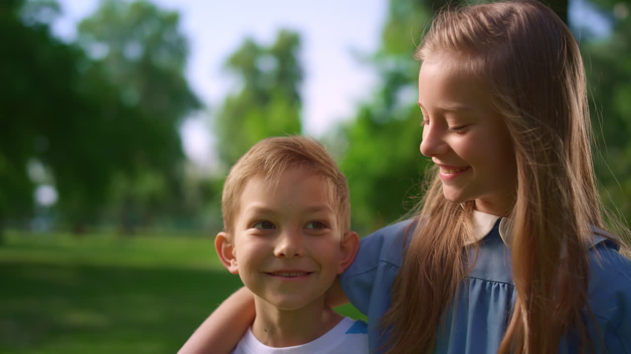 공원에서  ⁇ 안고 있는 사랑스러운 미소 짓는 형제자매, 공원에서 포즈를 취하는 10대 이전 아이들.