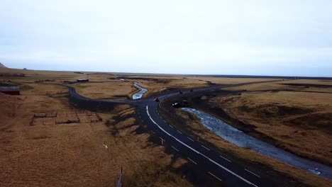 Vista-Aérea-Del-Paisaje-De-Quads-Rojos-Acelerando-En-Una-Carretera-Vacía-A-Través-De-Las-Tierras-Altas-De-Islandia