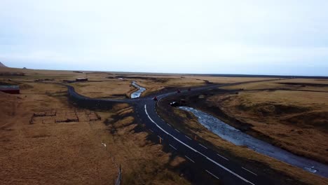vista aérea del paisaje de quads rojos acelerando en una carretera vacía a través de las tierras altas de islandia