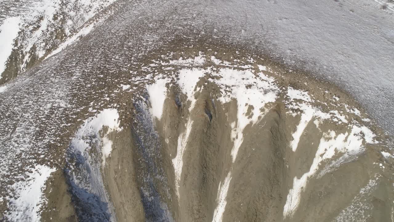 침식된 계곡이 있는 눈 인 산악 풍경