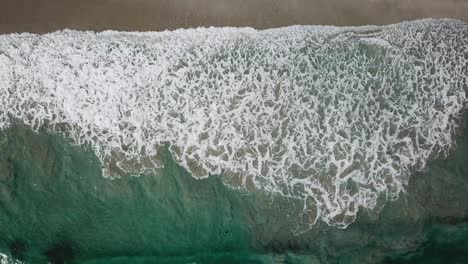 ondas de agua sobre arena marrón