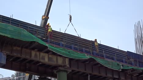 construction workers working at height installing reinforcement bar and form work at the construction site. they are requested to wear appropriate safety gear to prevent bad happen to them.