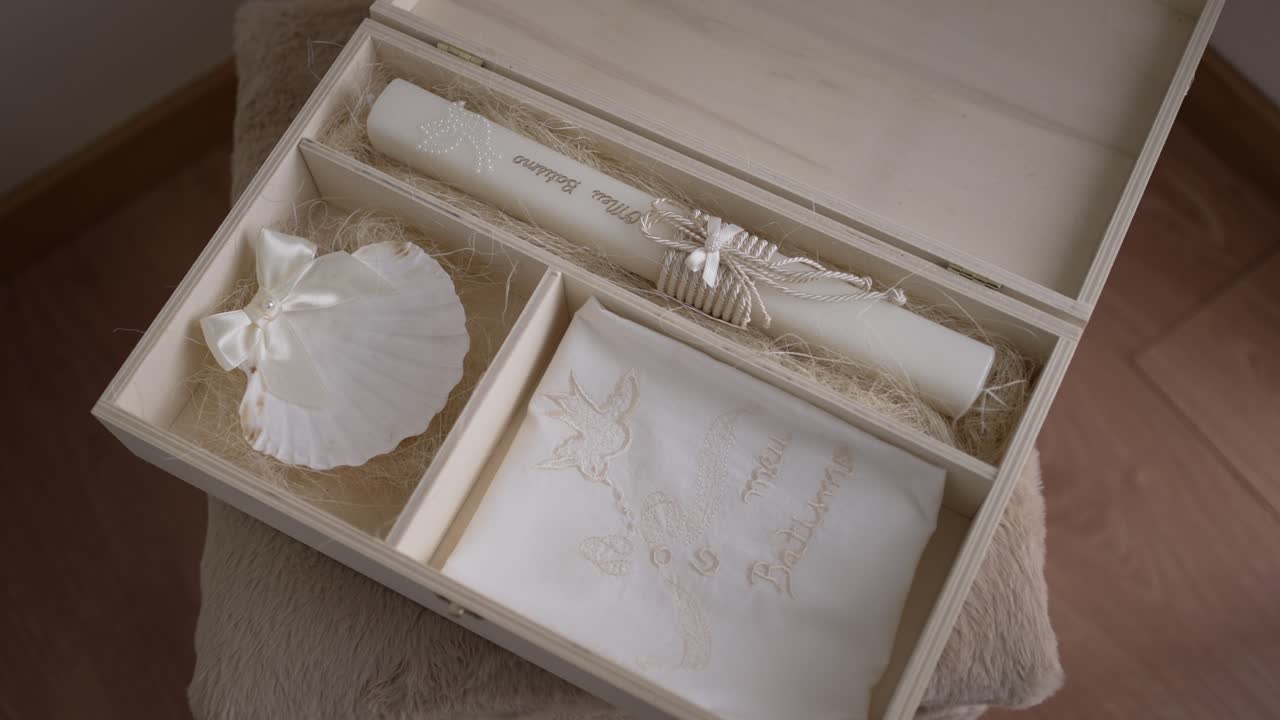 baptism keepsake box with candle shell and embroidered cloth on soft neutral tones