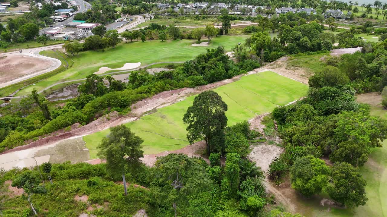 Drone footage captures lush green golf course in Phuket, Thailand, showcasing vibrant landscapes and serene environment under natural daylight
