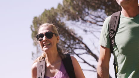 una pareja de excursionistas caminando por el bosque.