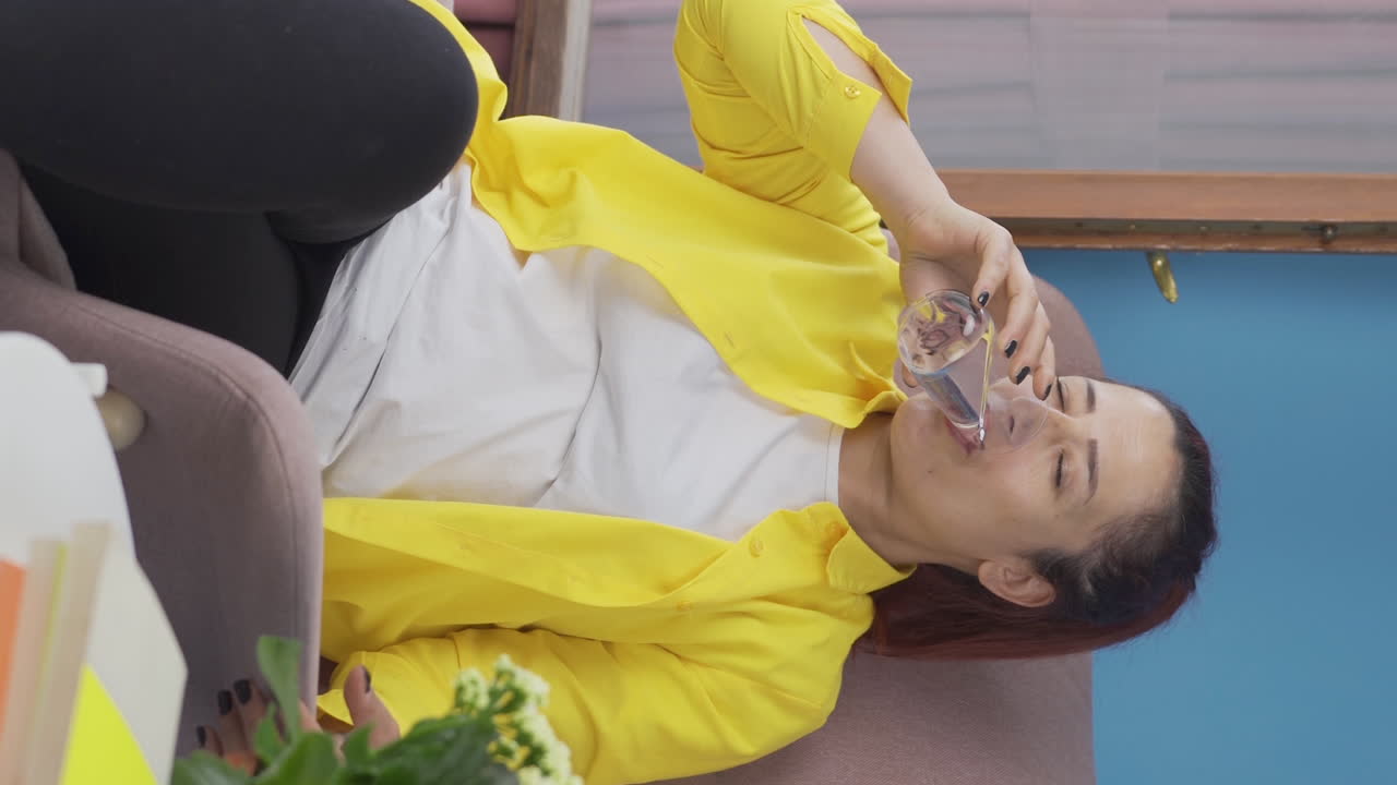 물을 마시는 여자의 수직 비디오.