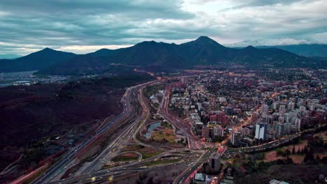 Aerial-view-dolly-in-of-the-commune-of-Vitacura-the-Manquehue-hill-in-the-background-with-clouds,-Santiago,-Chile