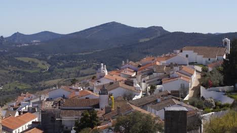 view of marvao village with beautiful houses and church with rocky landscape mountains behind