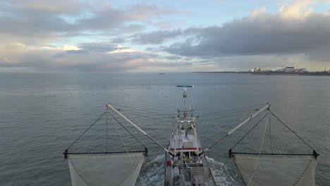 Traditional-Dutch-shrimp-trawler-boat-moving-through-sea-at-dawn