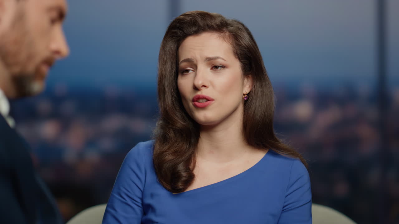 una mujer molesta entrevistando a un hombre en un programa de televisión.