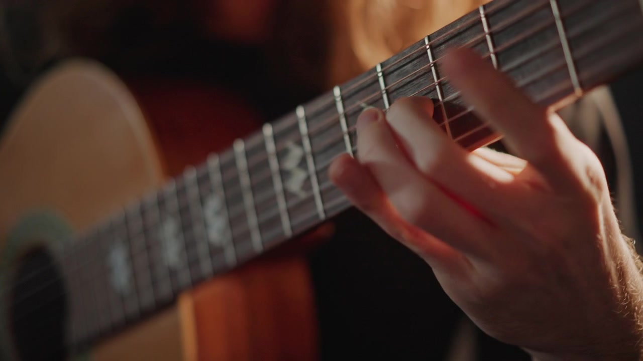 Nighttime guitarist performs intensely. Performing under spotlights with precise finger technique. Caucasian musician skillfully showcasing intricate finger movements during night performance