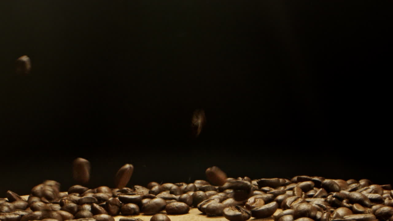 咖啡豆从上面落在木质表面上