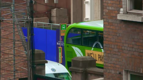 dublin bus passing the bus stop between brick houses