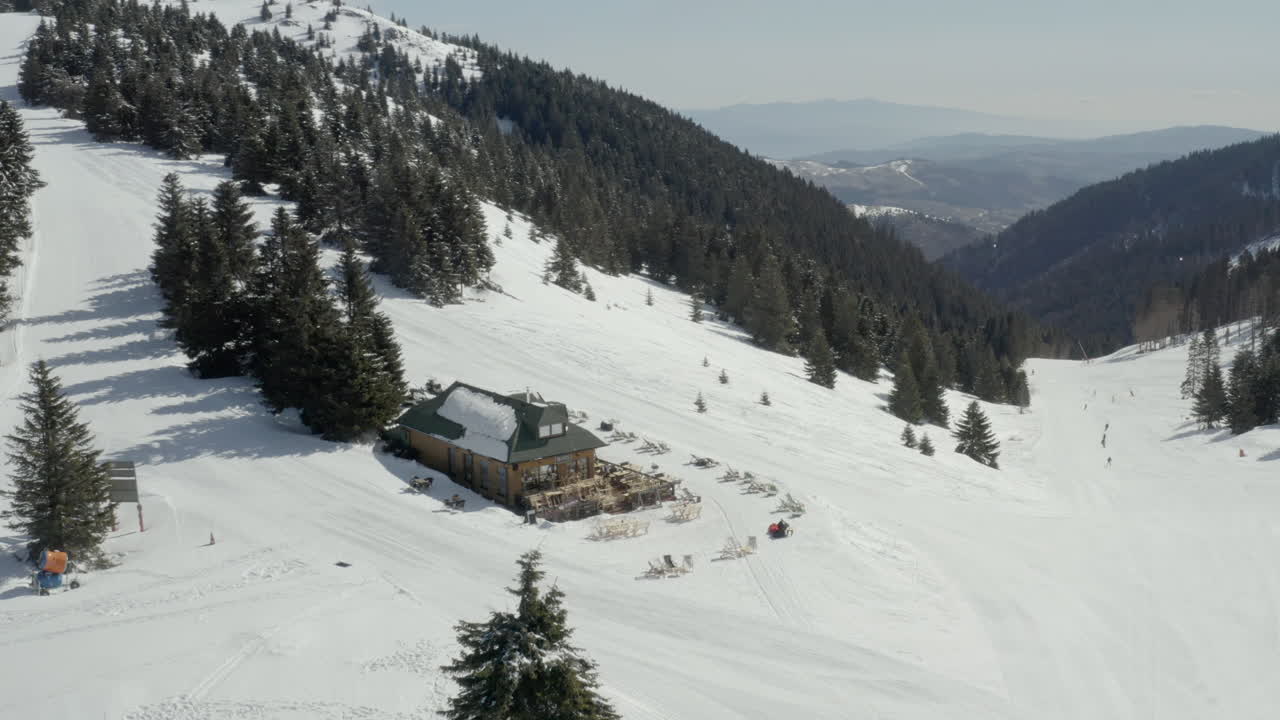 A scenic ski resort with a lodge and slopes amidst snowy mountains