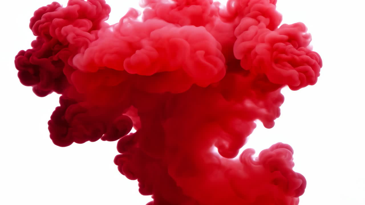 Red Smoke Cloud Formation on White Background. Bright red smoke billows upward against a white backdrop, creating a striking visual effect.
