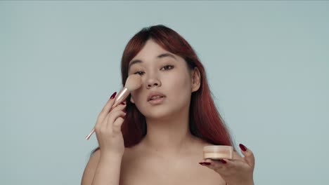 mujer aplicando polvo facial