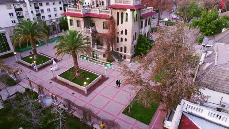 aerial orbit establishing of a couple walking hand in hand through the falabella palace in providencia santiago chile