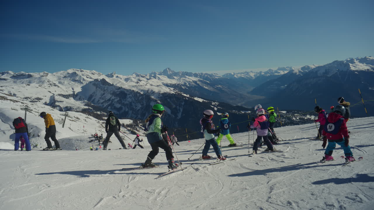 Scatto suggestivo di sciatori e snowboarder che si radunano in cima all'impianto di risalita di Anzère. Atmosfera alpina rilassata, viste panoramiche sulla Valle del Rodano, luce invernale brillante e limpida e un'autentica scena di vita del resort.