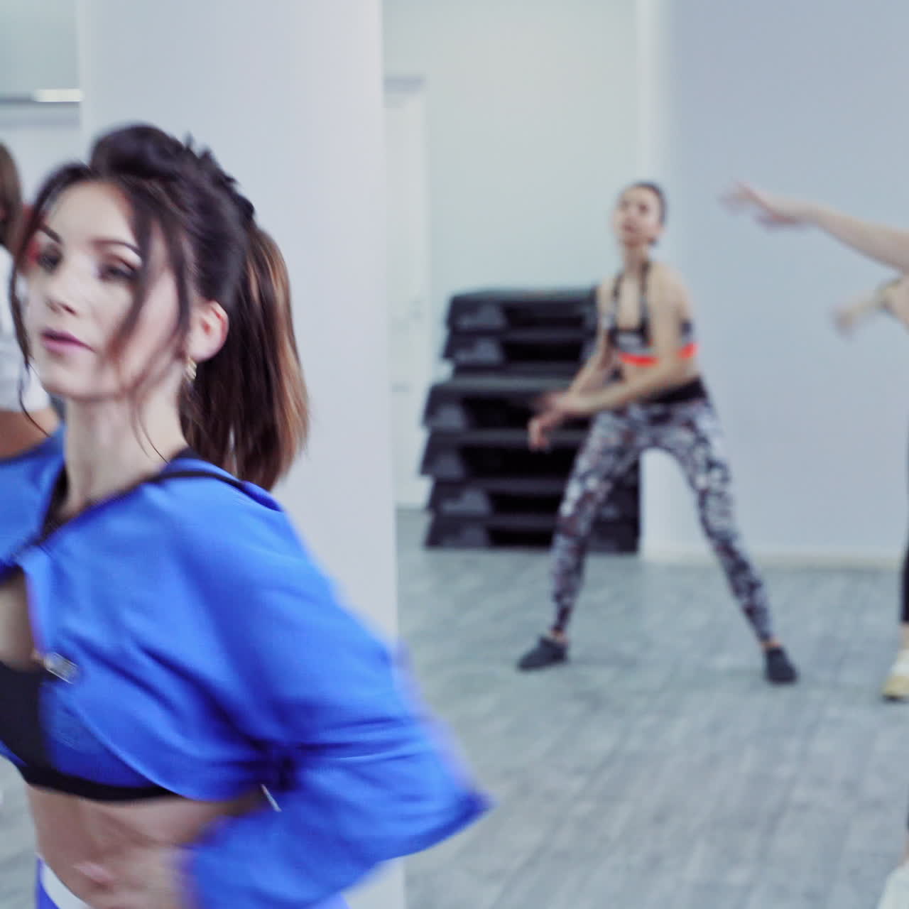 Beautiful sporty young women are working in gym on the background of fitness balls. A group of sports people exercise in fitness center. Athletic girls in sportswear indoors.