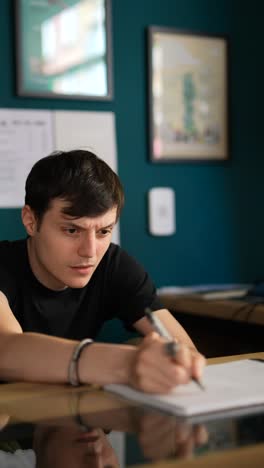 young man writing at a desk