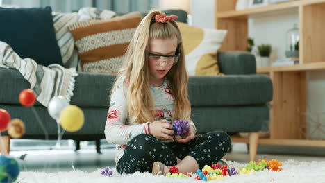 an adorable little girl playing with toy molecules